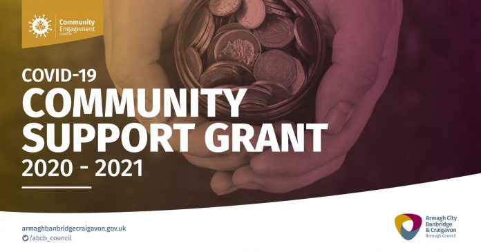 Graphic saying community support grant with a picture of a hand holding coins