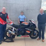 The photo shows Ryan Farquhar, Gwen Bartley and Billy Stewart with a motorbike.