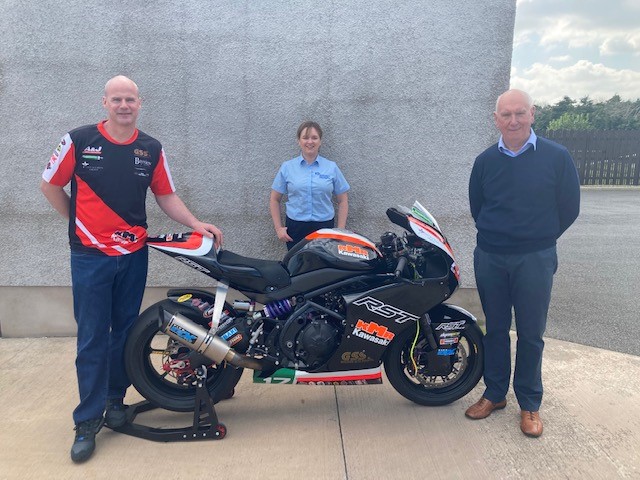 The photo shows Ryan Farquhar, Gwen Bartley and Billy Stewart with a motorbike.