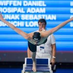 Male swimmer jumping off diving board