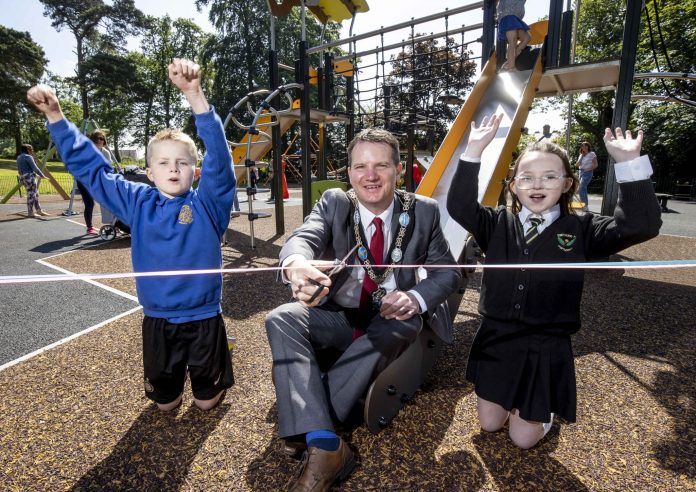 The Lord Mayor cuts the ribbon to officially open Edenvilla Play Park with two children cheering