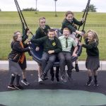 Children playing on a swing and laughing