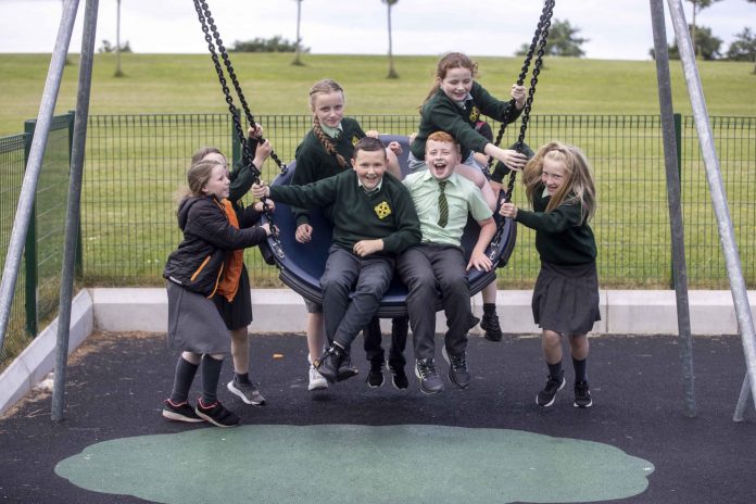 Children playing on a swing and laughing