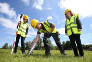 Two female students outside with high vis jacket and one male in high viz jacket.