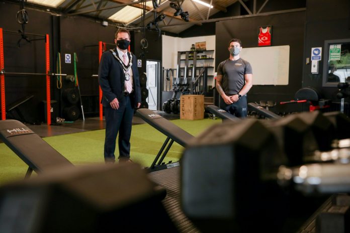 Two males standing indoors in gym