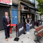 Male and female standing outside a cafe