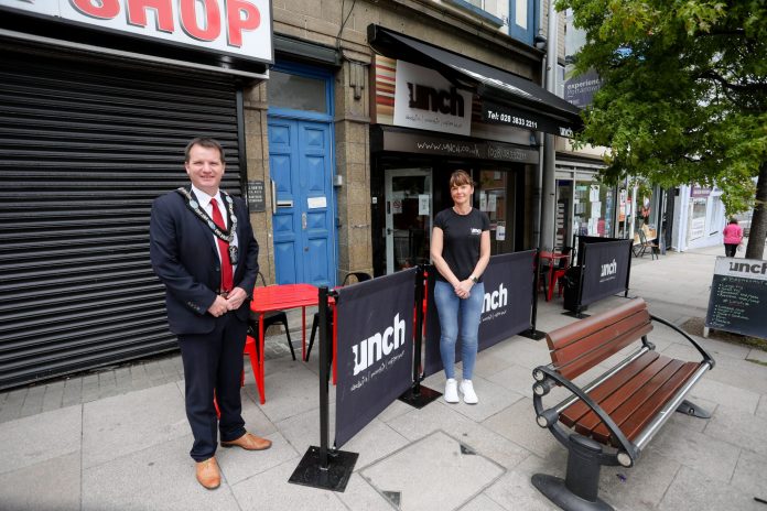 Male and female standing outside a cafe