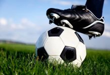 Photo shows a football with a boot resting on top of it