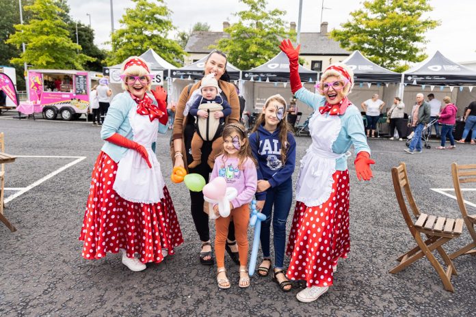 Local family beside performers at Portadown Pop up market