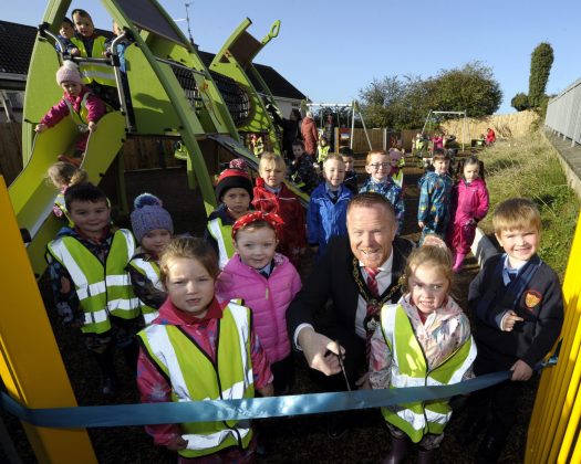 Lord Mayor of Armagh City, Banbridge and Craigavon, Councillor Paul Greenfield cuts the ribbon to officially open Frazer Park Play Park with children from St. Coleman’s PS and All Saints Nursery looking on.