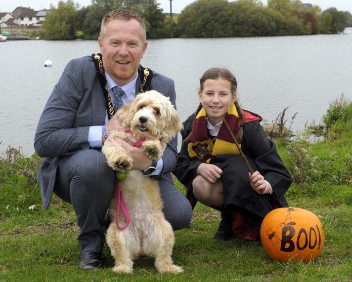 The Lord Mayor is pictured with his daughter dressed as Harry Potter and pet dog with a pumpkin saying the word boo.