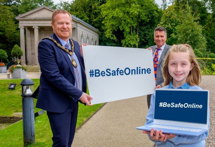 The Lord Mayor, Councillor Paul Greenfield and Safeguarding Coordinator Gary Scott hold a banner with the hashtag #BeSafeOnline while Lucia Greene holds a laptop with the same hashtag.