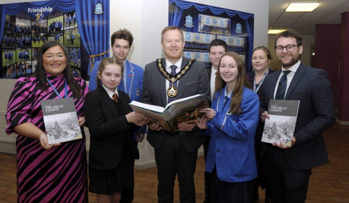 Lord Mayor, Councillor Paul Greenfield and Dolores Donnelly, Community Development Officer present copies of the Great Famine Education Programme booklet to Miss Caitlin Seeley, St. John the Baptist College and Mr Andrew Chambers, Killicomaine Junior High School along with pupils from both schools.