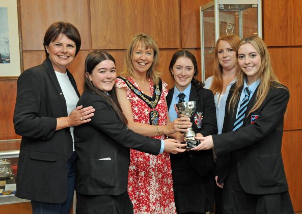 Six females holding a trophy.