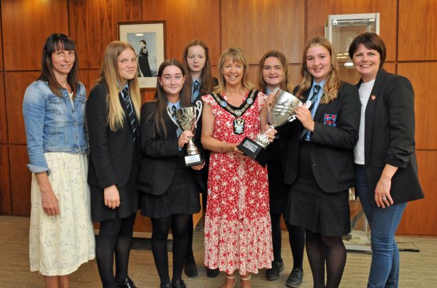 Small group of people standing holding a trophy.