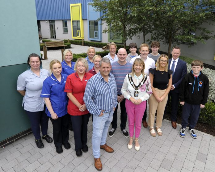 The photo shows a variety of people standing in the new garden at Blossom Children's Ward