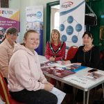 Four women sitting around a table at the job fair