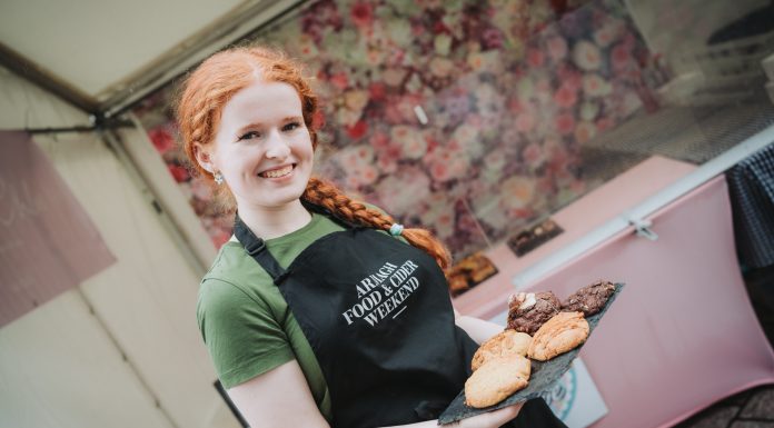 Girl showing a plate of local food at Food and Cider Market