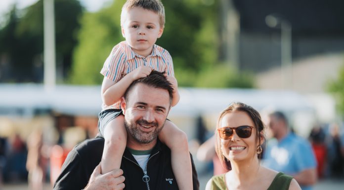 A mum, dad and little boy being held on his dad's shoulders