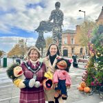 Lord Mayor and Claire Geddis standing in front of the Linen Bleachers Statues in Lurgan holding puppets