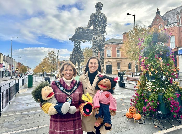 Lord Mayor and Claire Geddis standing in front of the Linen Bleachers Statues in Lurgan holding puppets