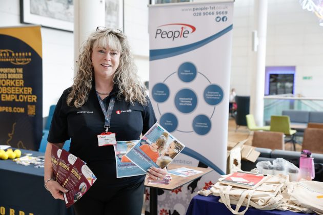 Woman holding leaflets for job programmes at job fair