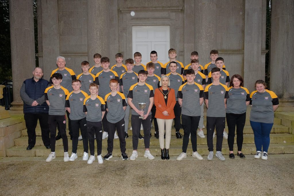 Male football team with elected members at civic reception. 
