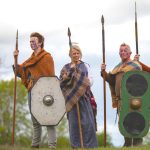 Three adults dressed as warriors at the Navan Fort Centre.