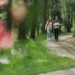 A male and female walking in the woods.