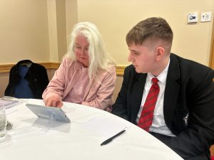A pupil from St Patrick’s Grammar gives guidance to an adult as part of the Digital Inclusion Programme Armagh.
