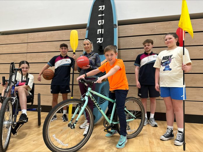 Group of people holding sports equipment to promote the getactiveabc summer activities.