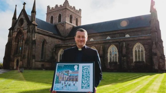 The Dean of Armagh, the Very Reverend Shane Forster, with a larger than life stamp St Patrick's Church of Ireland Cathedral, Armagh, will feature as the Second-Class Large Class stamp for its Christmas special stamps in 2024