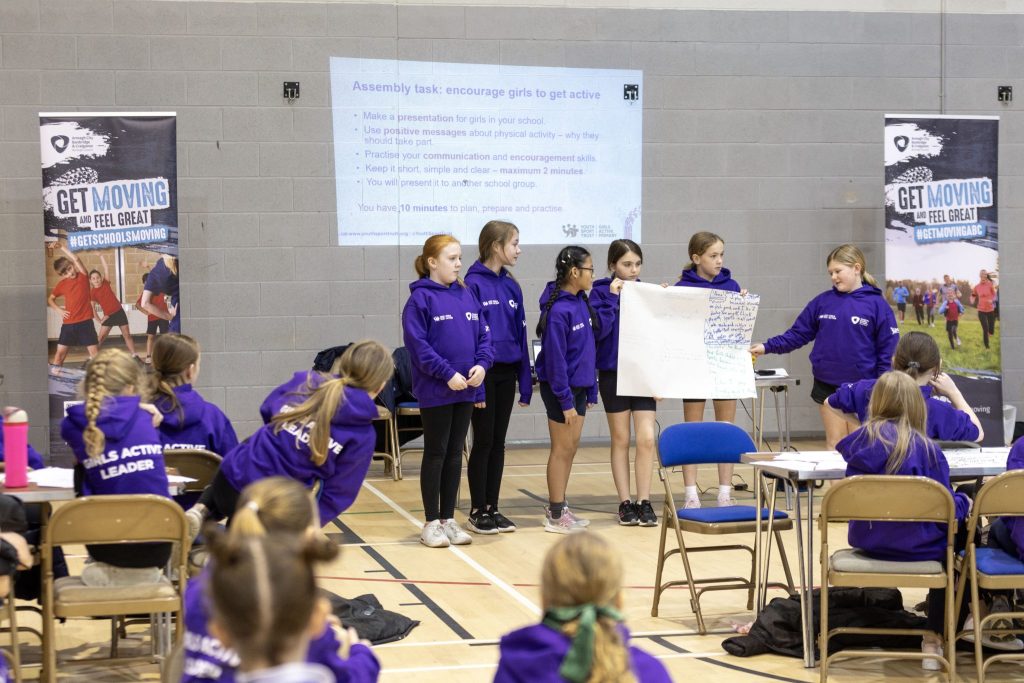A group of girls present their action plan to the audience.