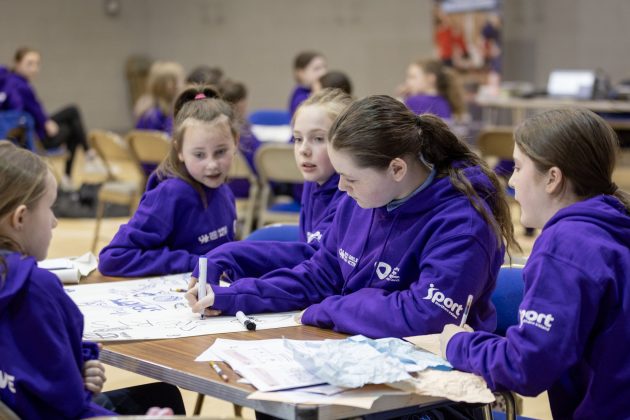 A group of young girls working on a poster.