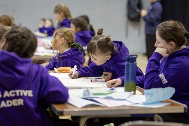 A group of young girls working around a table.
