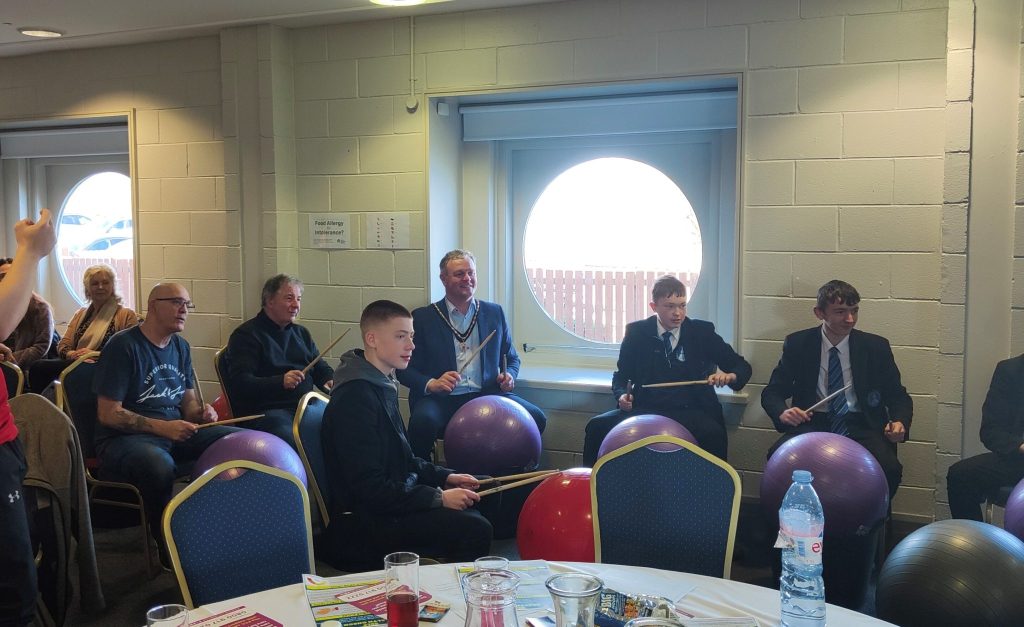 Deputy Lord Mayor Councillor Kyle Savage joins in on a drumming session with boys from local schools.