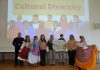A group of people standing in front of a screen which says 'Cultural Diversity'.