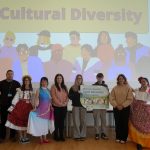 A group of people standing in front of a screen which says 'Cultural Diversity'.