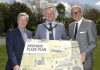 Three men hold a sign to promote the launch of the Dromore Place Plan.