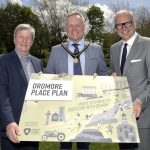 Three men hold a sign to promote the launch of the Dromore Place Plan.