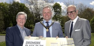 Three men hold a sign to promote the launch of the Dromore Place Plan.