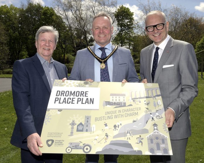 001 ©EBP DROMORE PLACE PLAN_EB53875 Three men hold a sign to promote the launch of the Dromore Place Plan.