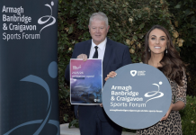 A male and a female are holding signs to promote the ABC Sports Forum.