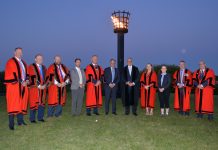 Group of men and women standing outside at night.