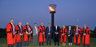 Group of men and women standing outside at night.