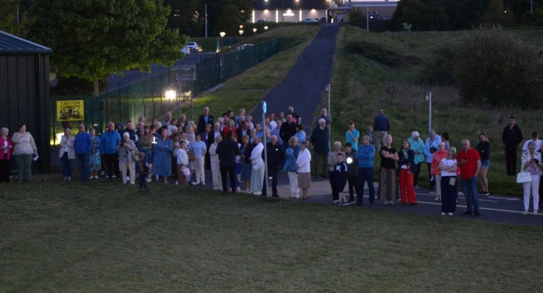 Large group of people standing outside.