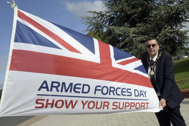 Man standing beside flag