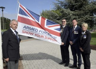 Small group of people outside with a flag