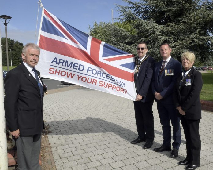 Small group of people outside with a flag