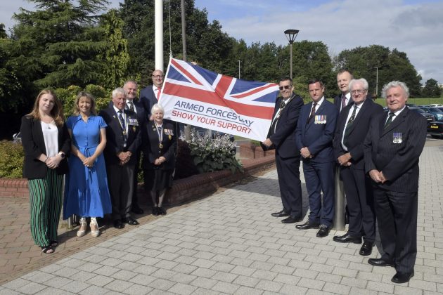 Group of people standing beside a flag